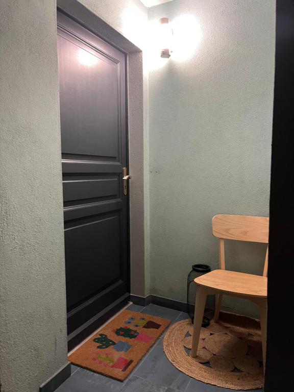 a room with a door and a chair and a rug at La Vitrine in Gertwiller