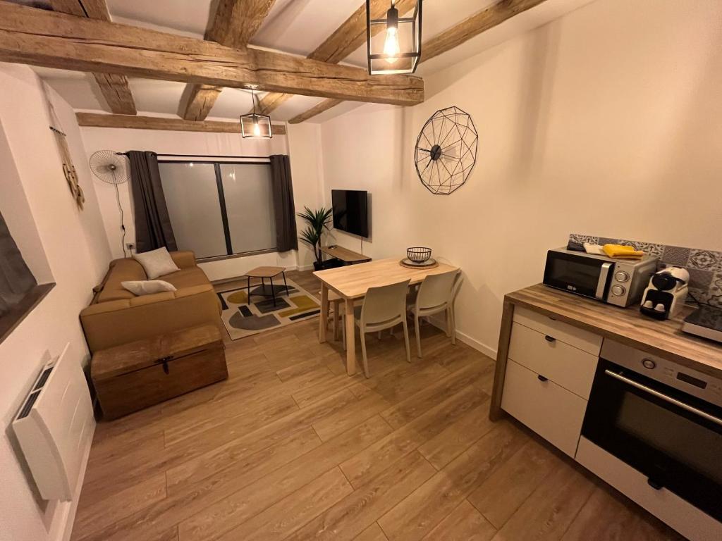 a kitchen and living room with a table and a microwave at La Vitrine in Gertwiller