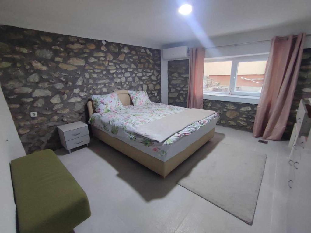 a small bedroom with a bed and a window at Apartments Janiki in Kruševo