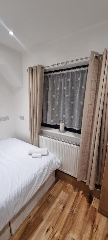 a bedroom with a bed and a window with curtains at Beautiful Rooms with free on street parking in Sydenham in Forest Hill