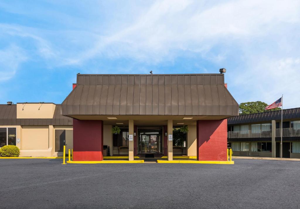 Un edificio con una bandera en un estacionamiento. en Red Roof Inn Reading, en Reading