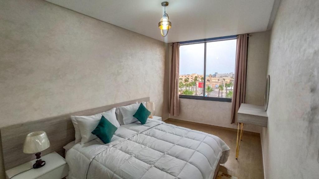 una camera con un letto bianco e una finestra di Palm D'or-Appartement familial de luxe au centre de Dakhla a Dakhla