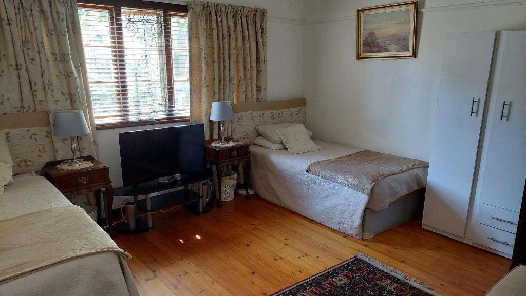 Habitación de hotel con 2 camas y TV en Glenette Residence, en Ciudad del Cabo