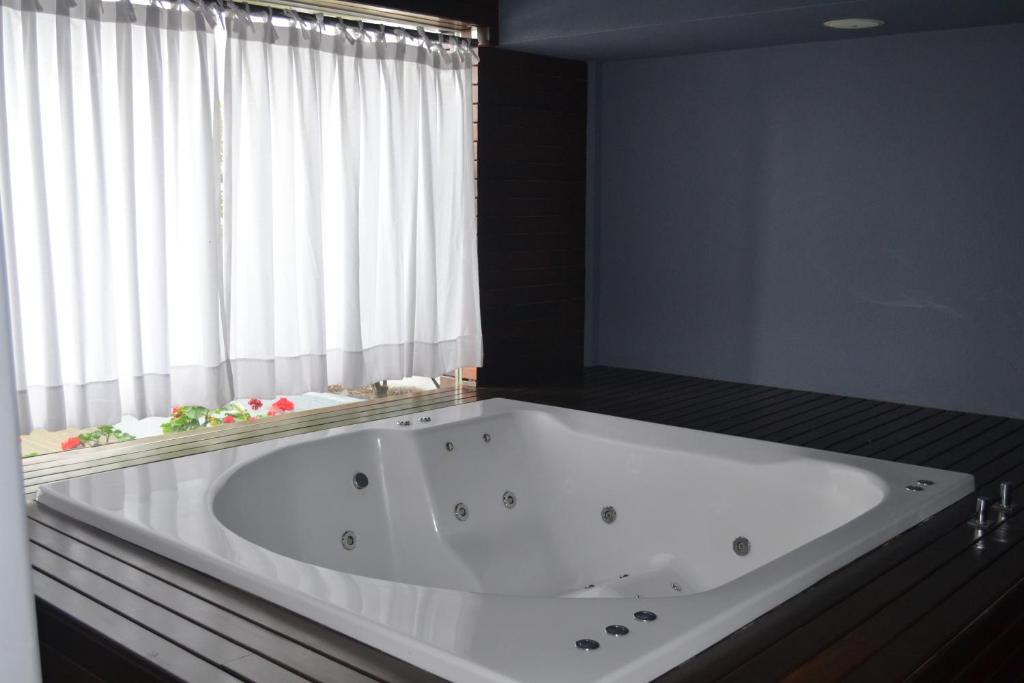 - une grande baignoire blanche dans une chambre avec fenêtre dans l'établissement Departamento nuevo en Puerto Madero - Torre 11 de Madero Harbour -, à Buenos Aires