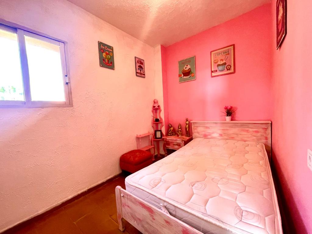 ein Schlafzimmer mit einem weißen Bett in einer rosa Wand in der Unterkunft Cosy room near beach and University in Valencia