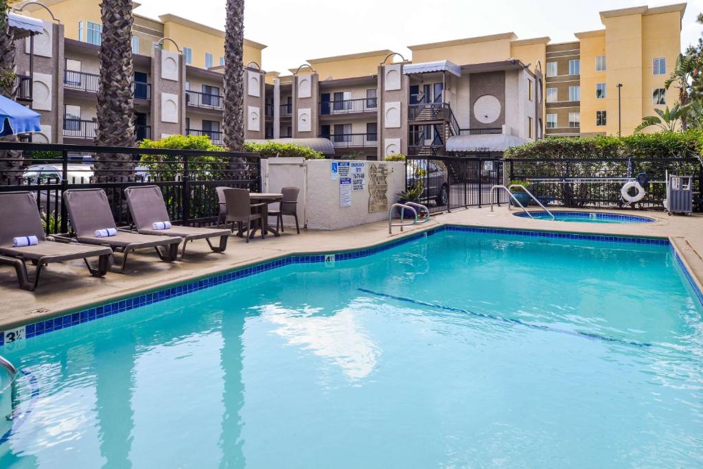 Best Western Courtesy Inn - Anaheim Park Hotel في أنهايم: مسبح في فندق فيه كراسي وشقق