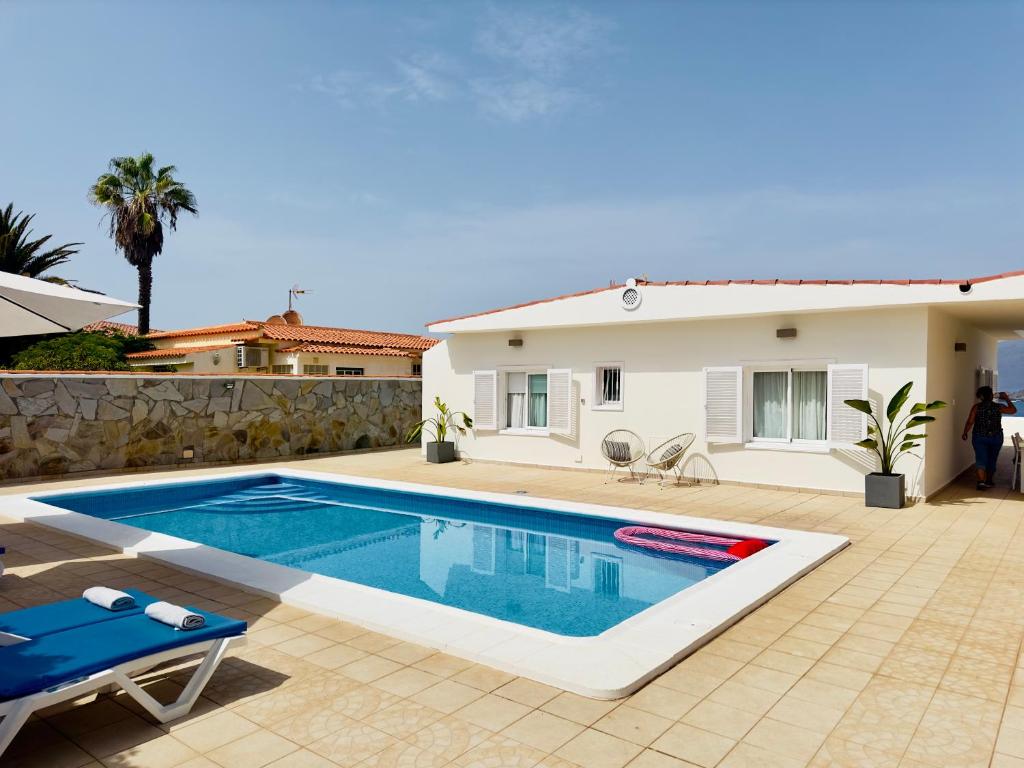 - une piscine en face d'une maison dans l'établissement Beachfront Villa and pool, à Puerto de Santiago