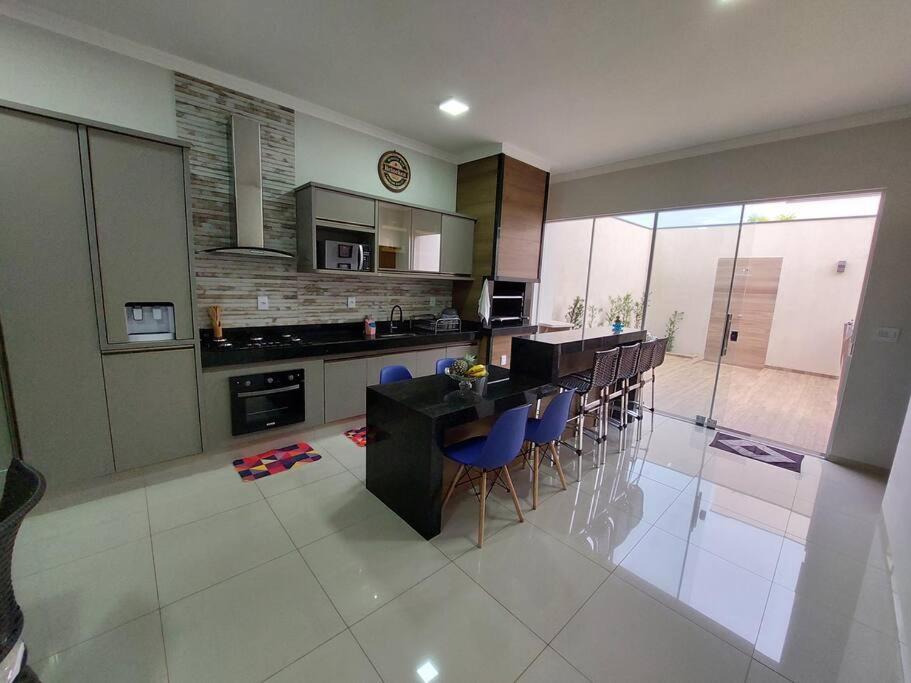 a kitchen with a table and chairs in a room at Casa de Temporada Maju - Olímpia - SP in Olímpia