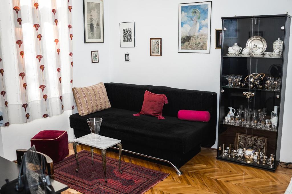 uma sala de estar com um sofá preto e uma mesa em Apartment Morgan - Historic Old Town Sarajevo em Sarajevo