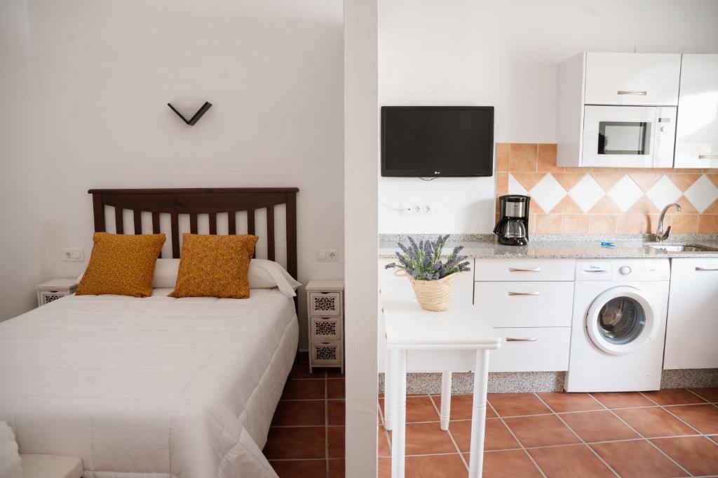 a bedroom with a bed and a kitchen with a washing machine at VIVE Trujillo in Trujillo