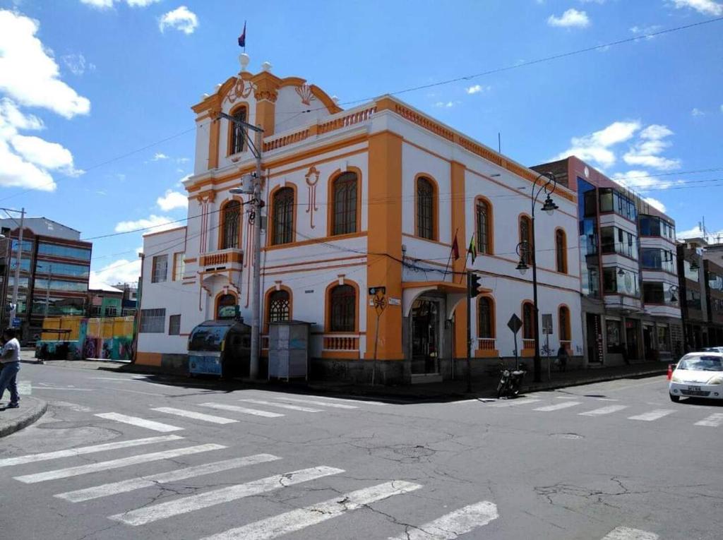 METROPOLITANO HOTEL في ريوبامبا: مبنى برتقالي وبيض على زاوية شارع