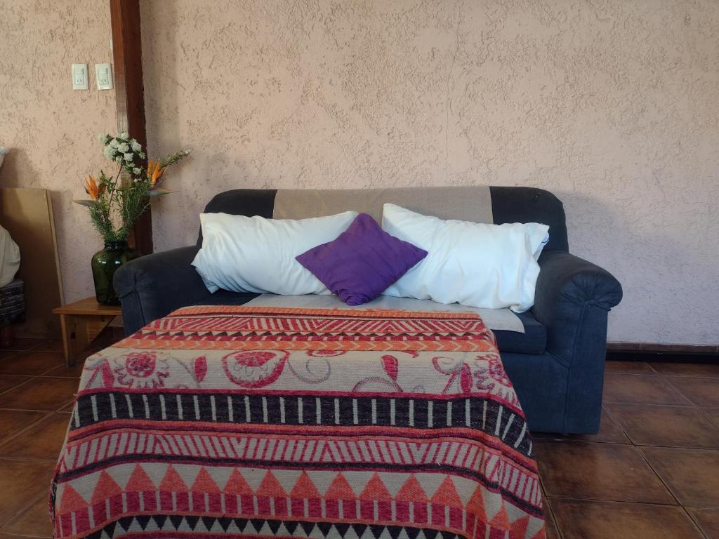 a blue couch with pillows and a blanket on it at Maipú soñado in Maipú