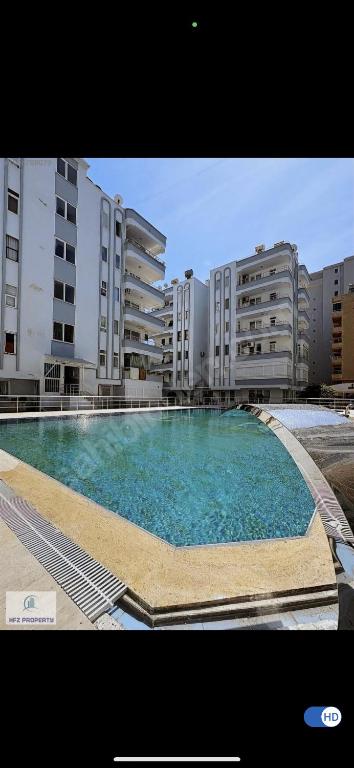 a large swimming pool in front of some buildings at Murat Baris Residence in Alanya