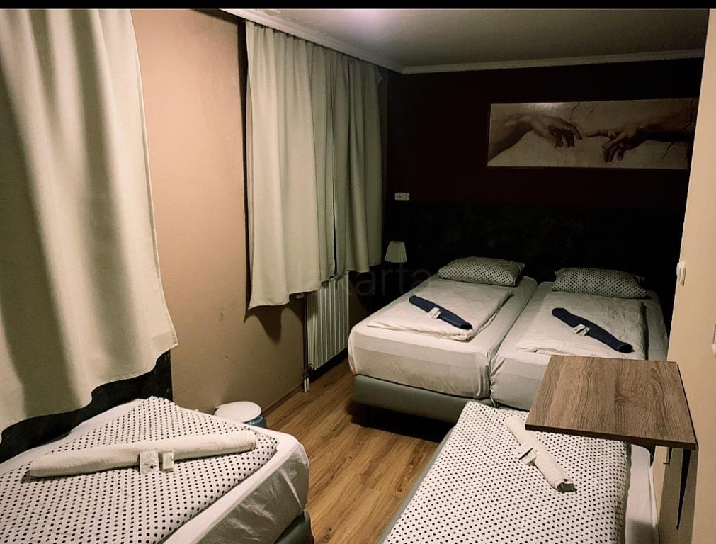 Habitación de hotel con 2 camas y mesa en Pasa Han Hotel M1autópálya, 