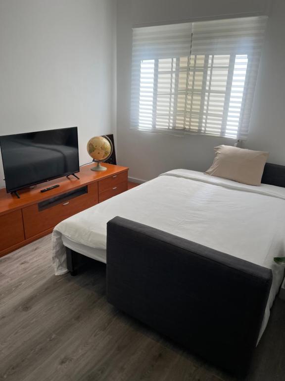 een slaapkamer met een bed en een flatscreen-tv bij Paço de Arcos - Lisboa in Paço de Arcos