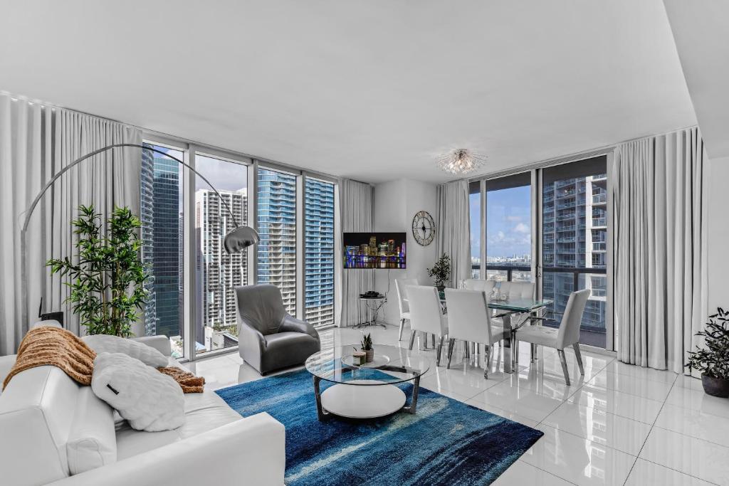 un soggiorno con divano bianco, tavolo e sedie di Luxurious Condo at ICON with Views a Miami