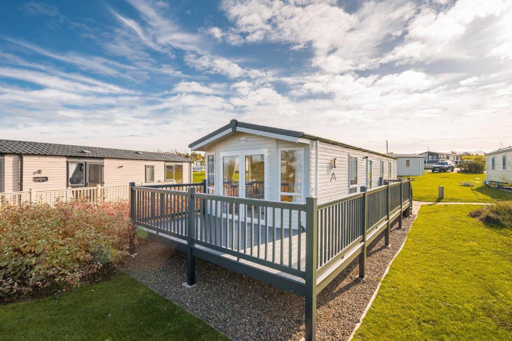 a tiny house with a deck in a yard at Lisa Marie-Luxury Caravan-Seton Sands-8 Berth in Port Seton