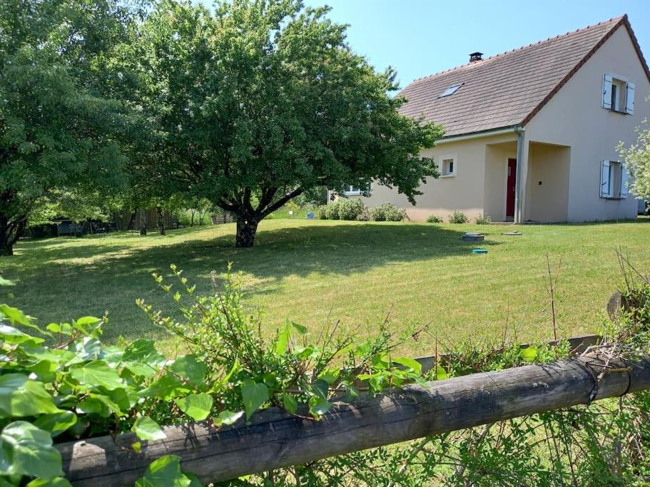 a house with a yard with a tree and a fence at Maison Au P'tit Bonheur in Argenton-sur-Creuse