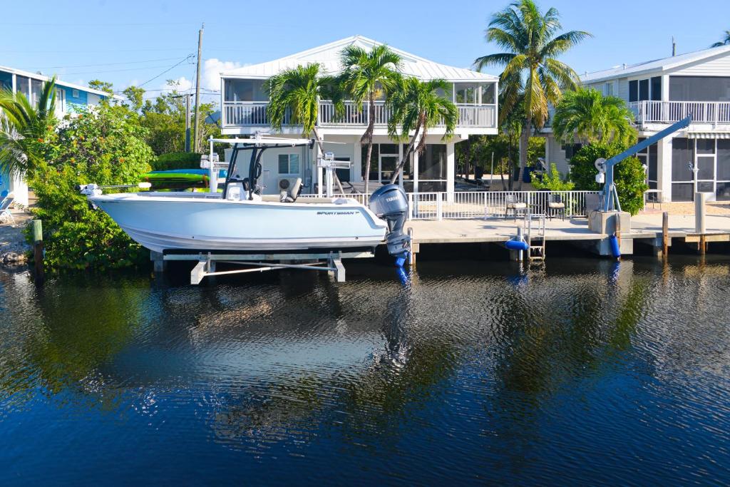 ein Boot, das an einem Dock vor einem Haus angedockt ist in der Unterkunft Two J’s Paradise in Key Largo