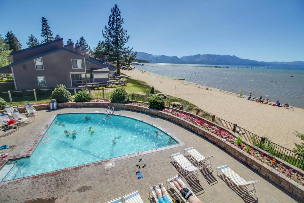 ein Pool neben einem Strand und einem Haus in der Unterkunft Lakeland Village by DC in South Lake Tahoe