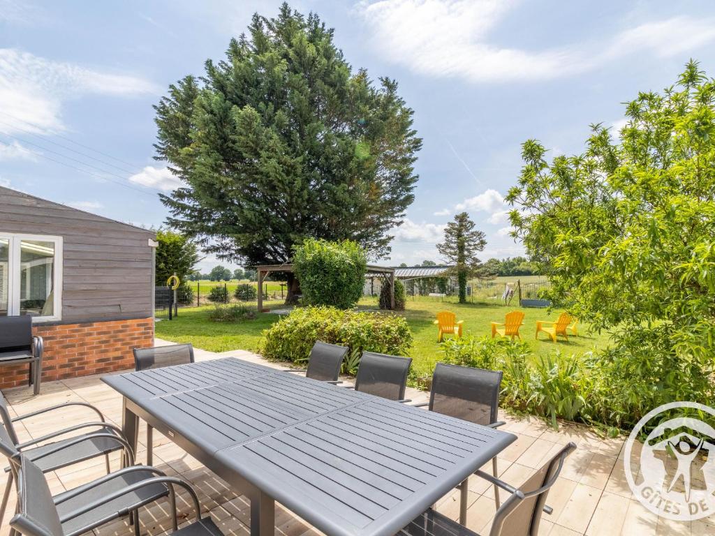 a patio with a table and chairs and a yard at Maison spacieuse avec spa, salle de jeux, proche Angers – Idéal familles et pros ! - FR-1-622-59 in Chazé-sur-Argos