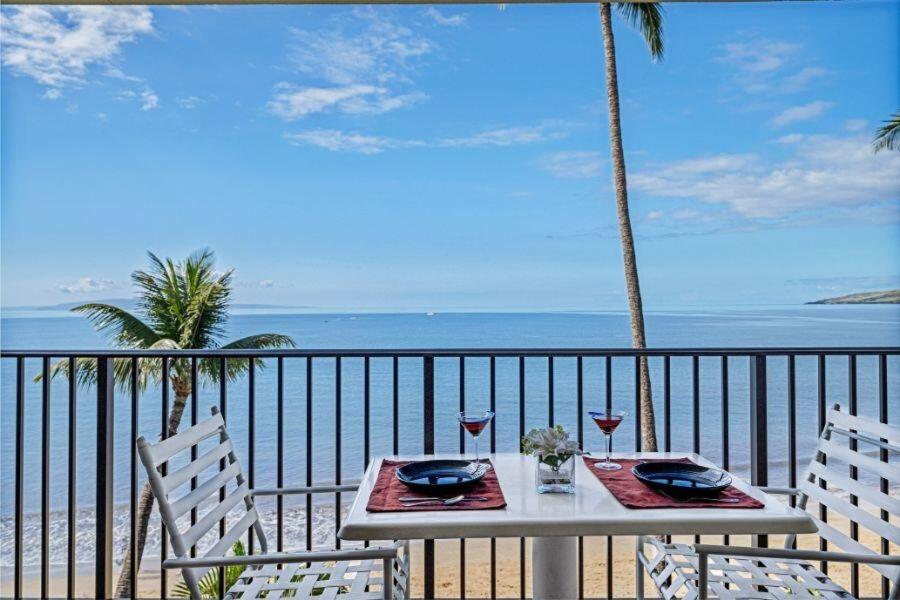 a table and chairs with a view of the ocean at KIHEI BEACH, #406^ condo in Kihei