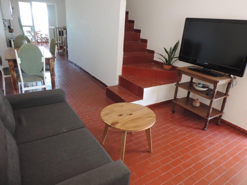 烏拉圭河畔康塞普西翁的住宿－Depto 9 de Julio，带沙发和电视的客厅以及楼梯。