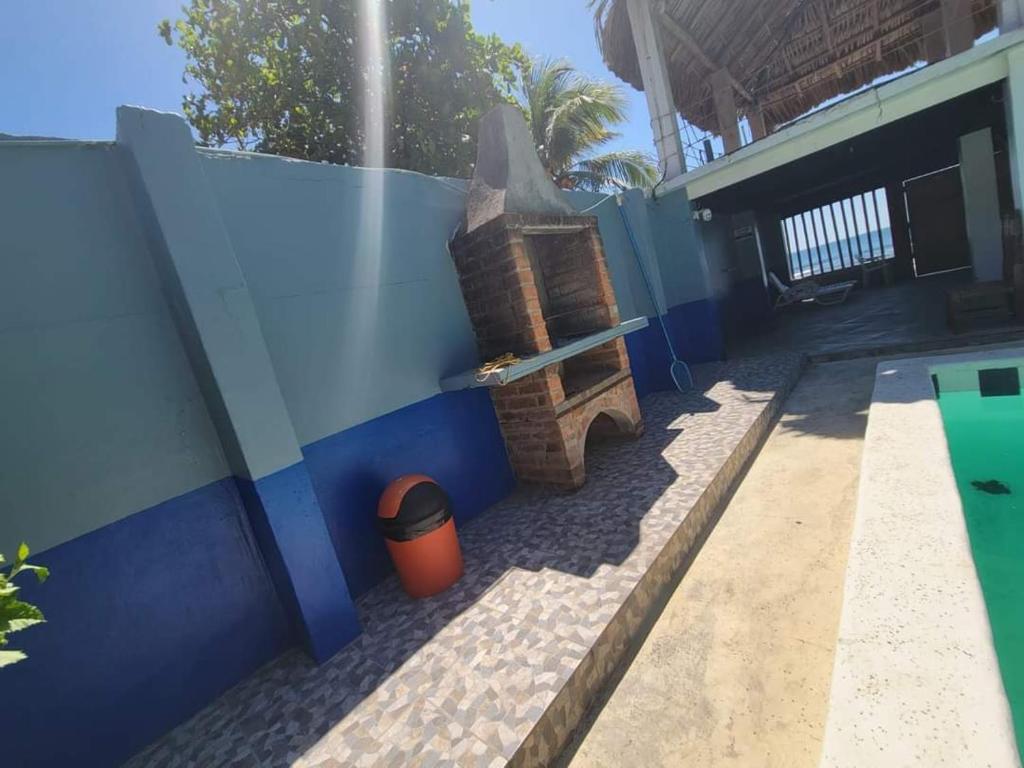 een huis met een blauwe muur en een vuilnisbak bij Rancho Hostal Mar in Sonsonate