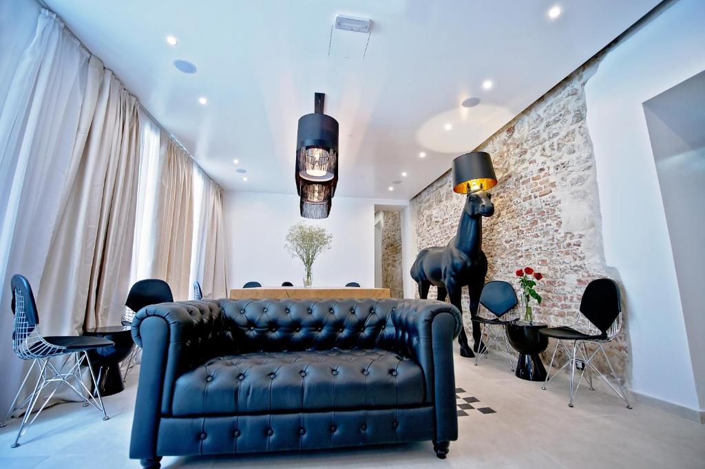 a living room with a blue couch and a brick wall at Jupiter Luxury Hotel in Split