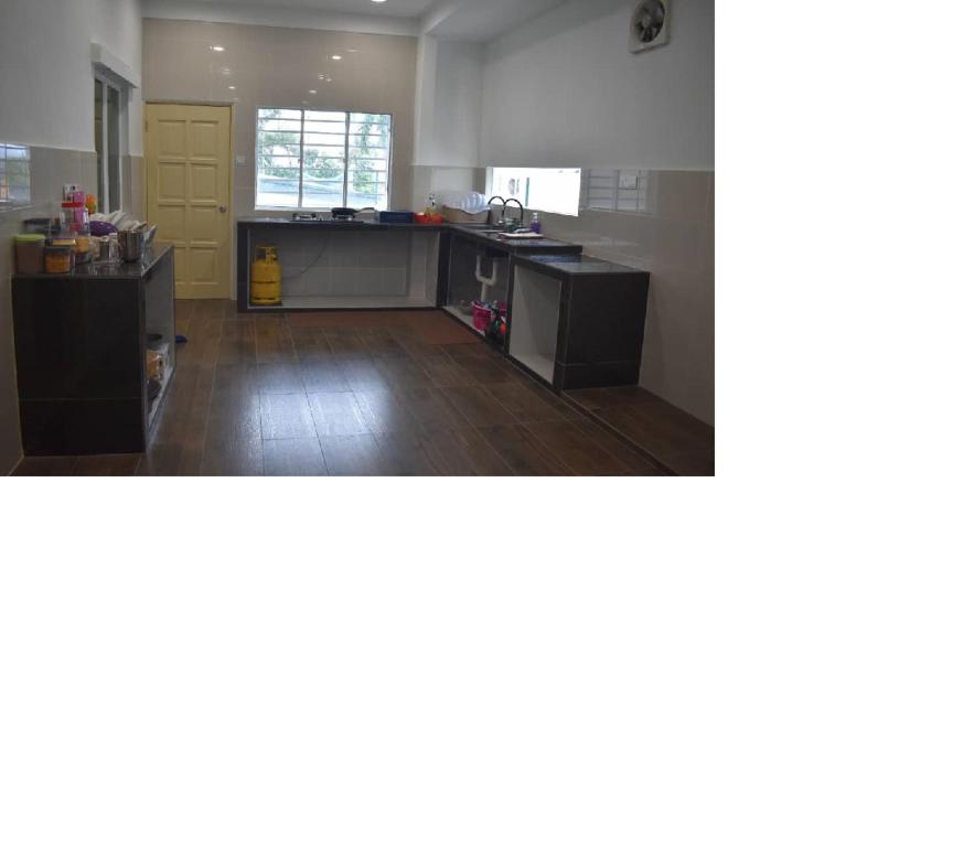 a kitchen with wooden floors and a kitchen with a counter at Room for short stay with shared facilities in Seremban