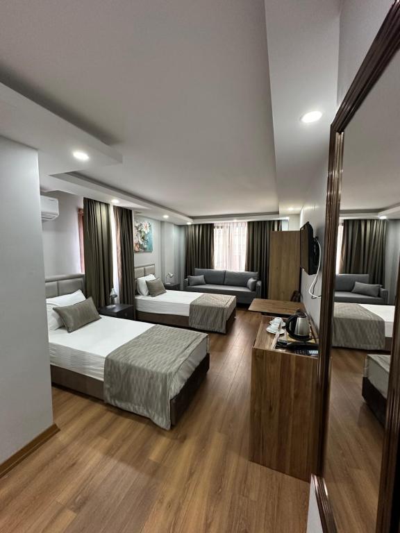 a hotel room with two beds and a couch at Marista Pansiyon in Istanbul