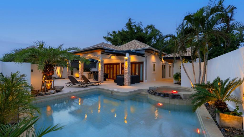 a swimming pool in front of a house at Orchid Paradise Homes OPV 210 in Hua Hin