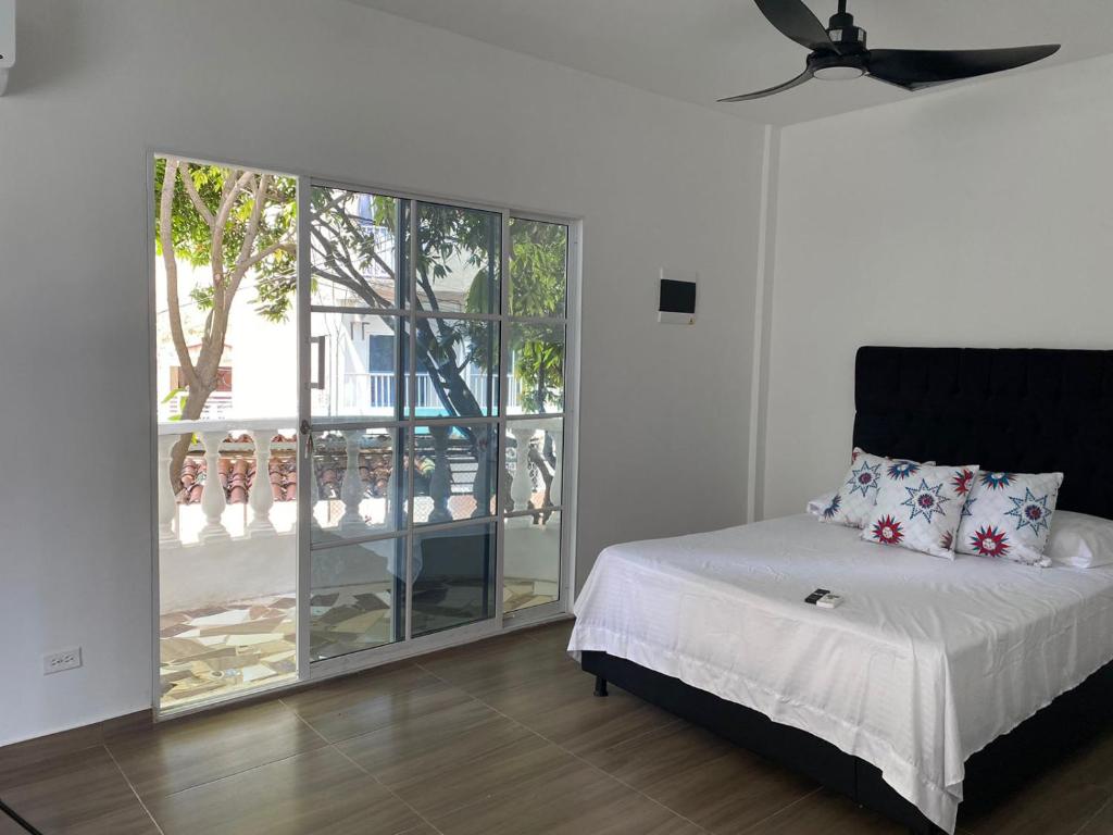 a bedroom with a bed and a large window at Habitaciones y aptos Isabella in Santa Marta