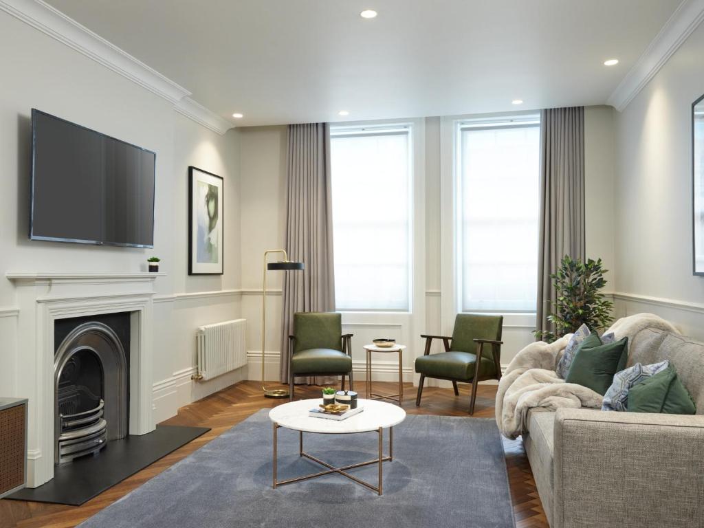 a living room with a fireplace and a tv at Uber Mayfair Luxury Apartment in London