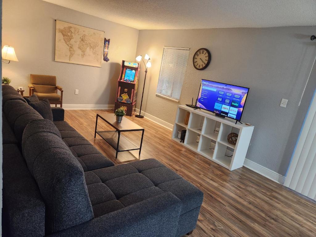 ein Wohnzimmer mit einem Sofa und einem Flachbild-TV in der Unterkunft Centauri Vacation Rentals Beautiful 2-bedroom condo, near all Orlando attractions, free parking & Wi-Fi, King bed in Orlando