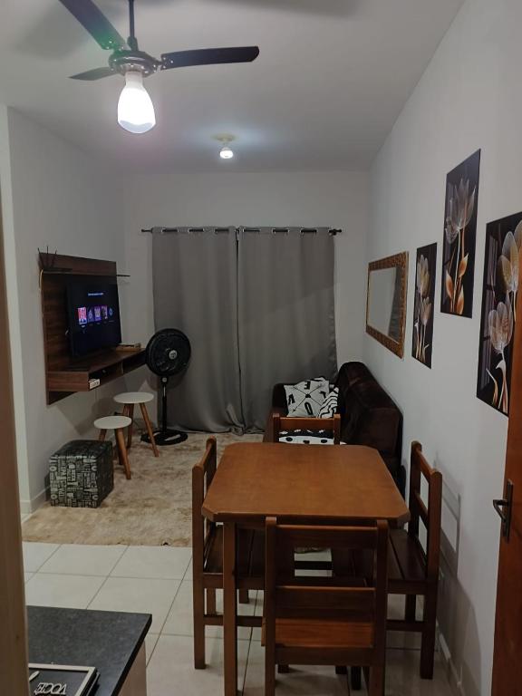 een woonkamer met een tafel en een bank bij Apartamento encantador 22 in Ubatuba