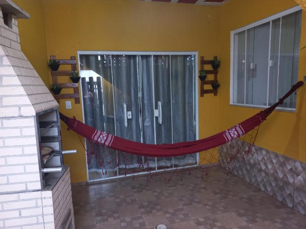 a hammock in the corner of a room with a window at Kitnet Arraial do Cabo, Monte Alto. in Arraial do Cabo