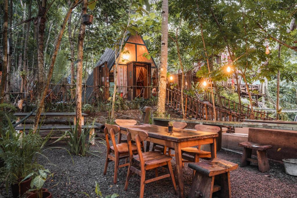 a table and chairs in front of a tree house at Awandaru Village in Yogyakarta