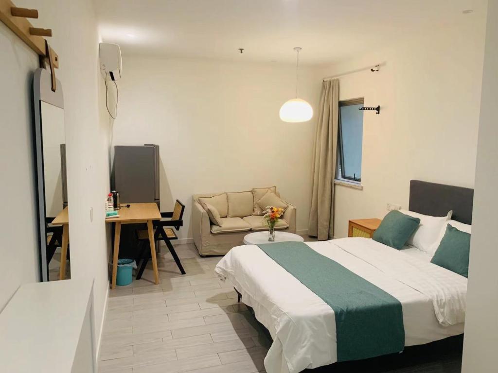 a hotel room with a bed and a couch at YueShe Apartment - HongQiao Longbai Xincun in Shanghai