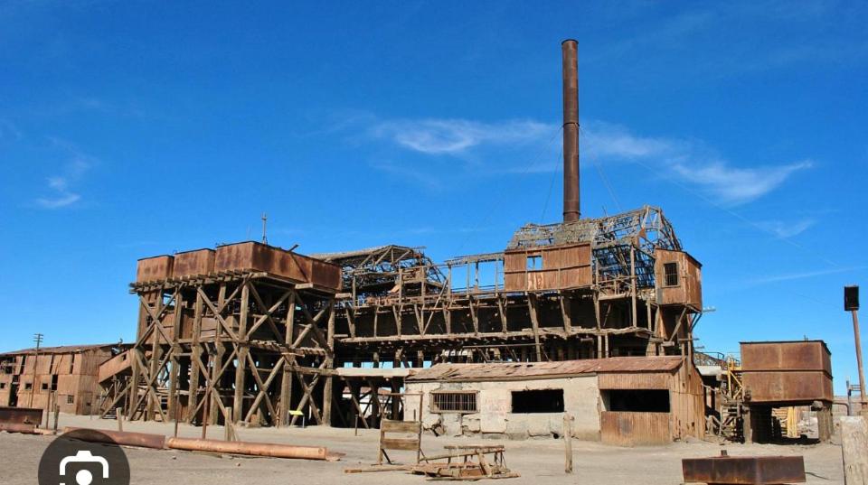 una vieja fábrica con una chimenea alta encima en Matiz, en Iquique