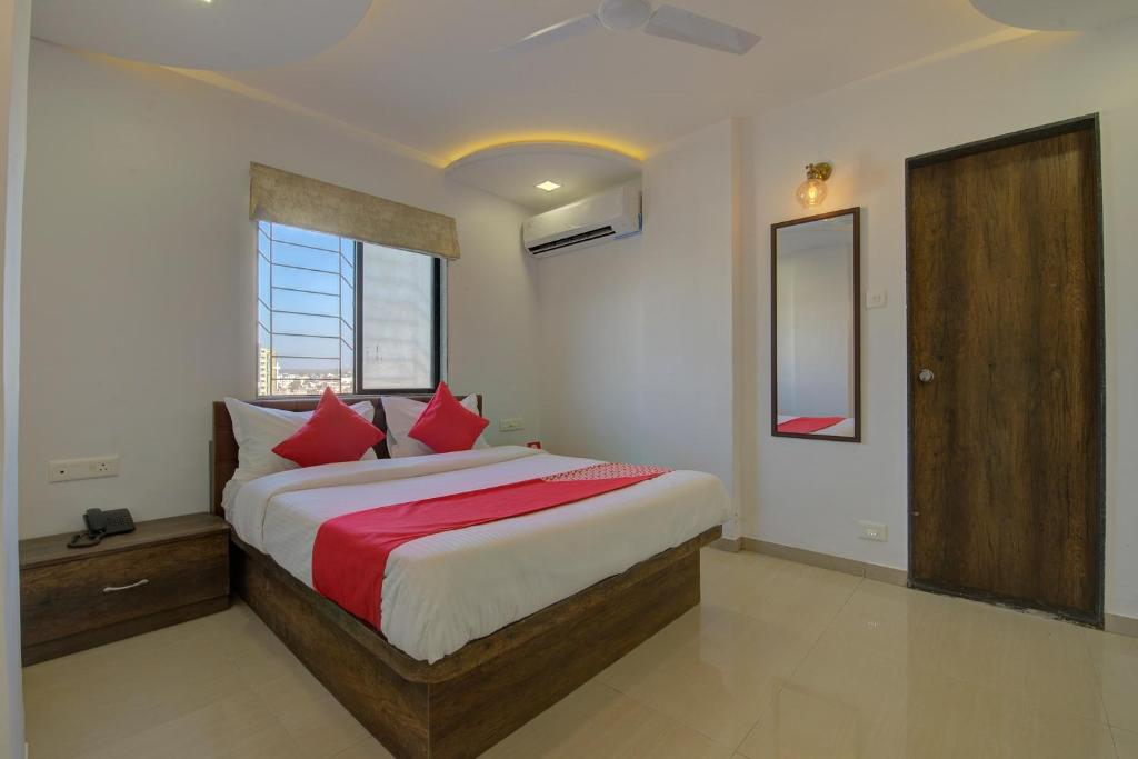 a bedroom with a large bed with red pillows at RK regency in Yerandwane