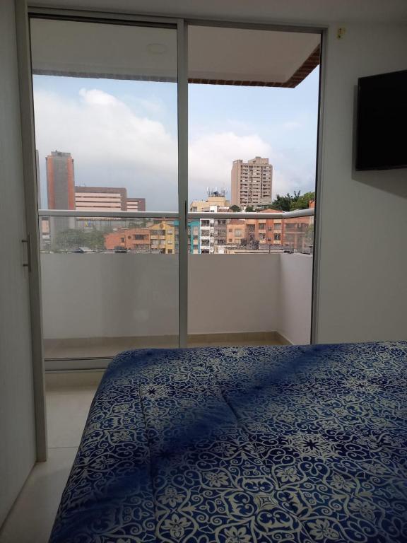 - une chambre avec un lit et une grande fenêtre dans l'établissement Apartamento Sabaneta sector Mayorca, à Sabaneta