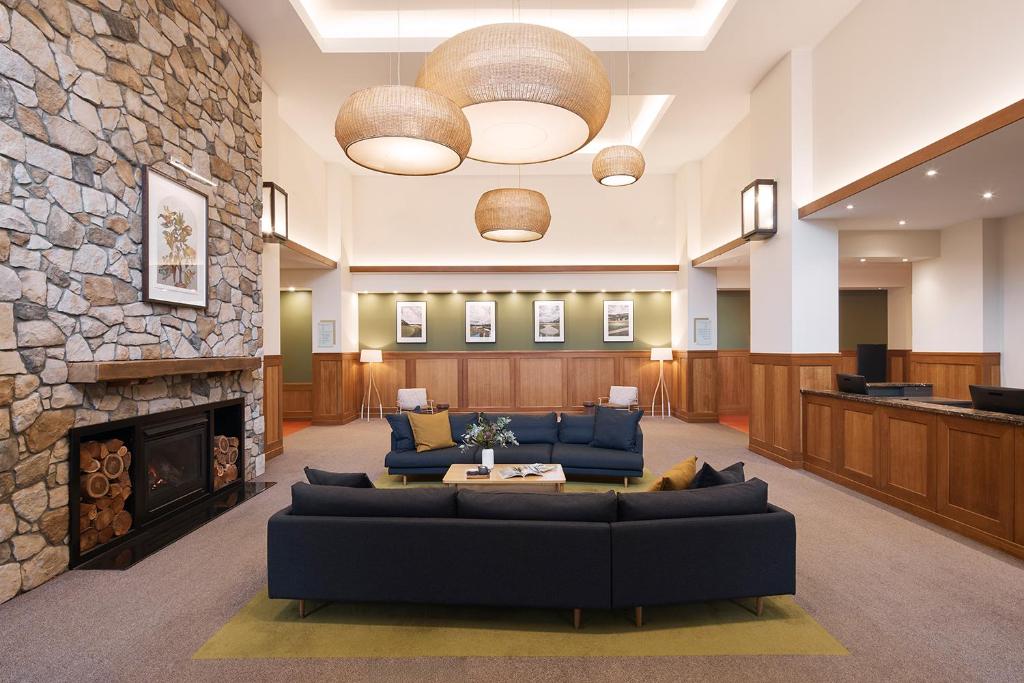a lobby with couches and a stone fireplace at Yarra Valley Lodge in Wonga Park