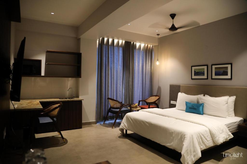 グレーター・ノイダにあるBelvedere Suitesのベッド、デスク、椅子が備わるホテルルームです。