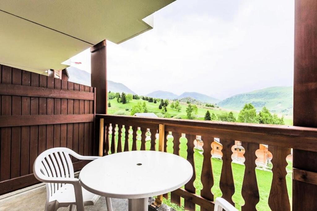 une table et des chaises sur un balcon avec vue dans l'établissement Résidence Les Mélèzes - maeva Home - Studio 5 personnes - Sélection MAE-1344, à Huez