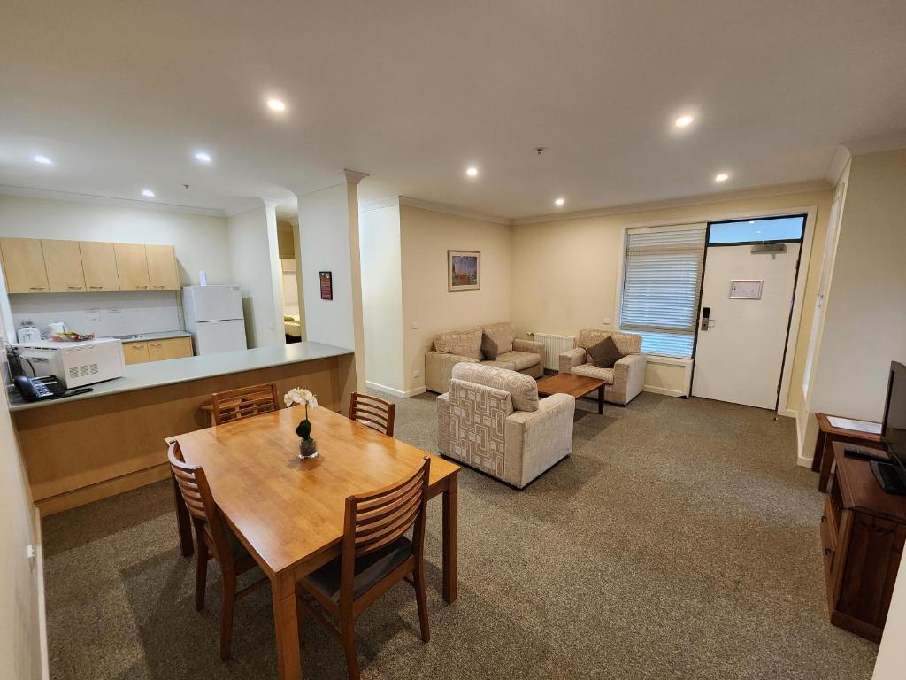 eine Küche und ein Wohnzimmer mit einem Tisch und Stühlen in der Unterkunft Mary MacKillop Heritage Centre in Melbourne