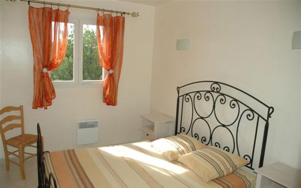 une chambre avec un lit, une chaise et une fenêtre dans l'établissement Gîte La résidence n° 4, à Bauduen