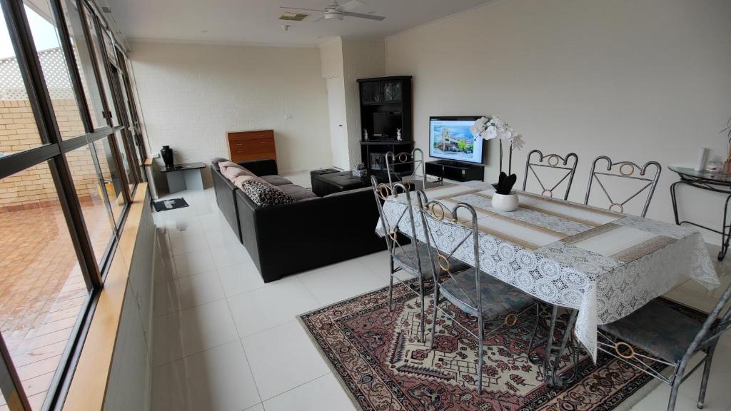 a living room with a table and a couch at Tuggeranong Short Stay #11C - Sleeps 8 in Canberra