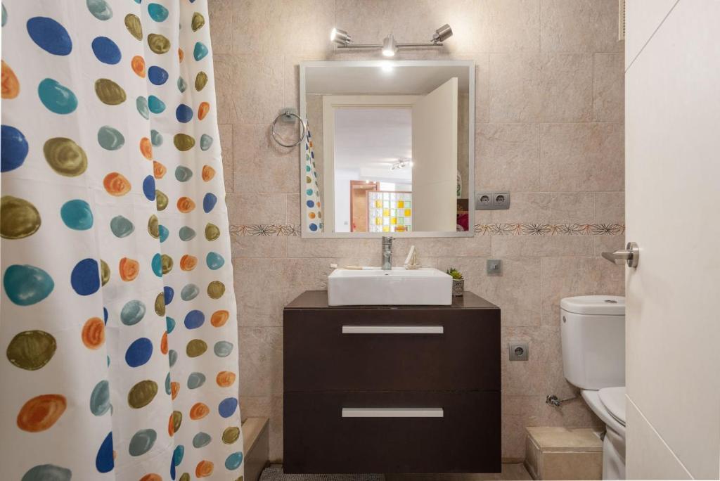 Un baño con lavabo, espejo e inodoro. en Apartment Lyon - Alcúdia - ETVPL15408, en Alcudia