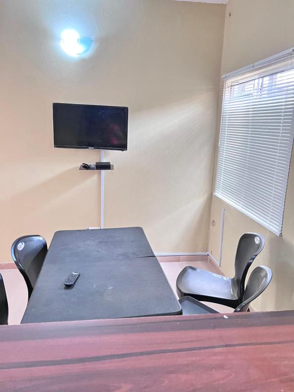 a conference room with a table and chairs and a tv at A Home Away From Home in Mawere